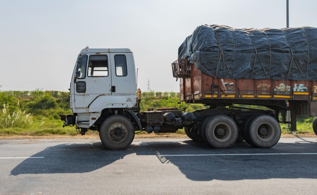 Side view of an Indian truck on a highway in Deeg, Uttar Pradesh, India during the day.